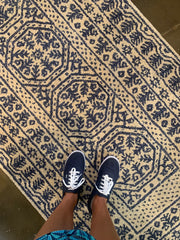 Photo of feet on a blue and white rug.