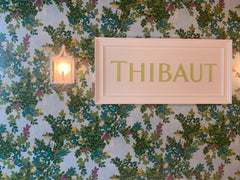 Thibaut signage on a floral wallpaper.