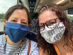 Photo of me and Marissa wearing masks on the charter bus.