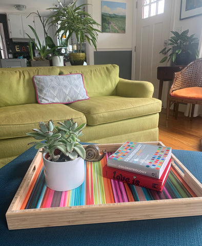 living room POV photo with multicolor wooden tray on a navy ottoman.