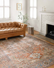 loloi terracotta sky rug in living room with fireplace and brown leather sofa