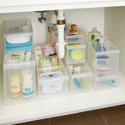 Clear plastic storage containers organized under kitchen sink