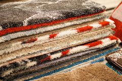 Close up of the edges of a stack of various rugs
