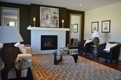 Neutral and brown living room, set up around a fireplace.