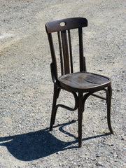 dark brown older style chair sitting outside