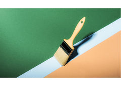Paint brush on a white line surrounded by green paint on top and yellow on bottom
