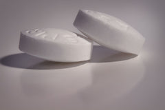 Close up image of 2 tablets of aspirin.