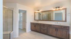 White bathroom with a long medium wood vanity