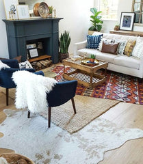 Small living room with a fireplace and 3 rugs are layered