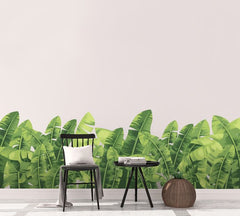 Wall with large banana wall stickers, wooden chair sitting in front.