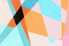 Geometric wall mural in various colors like orange, pink and teal.
