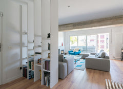 Open shelving with books on it helping to divide up a large living room space.