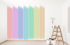 Pastel paint colors painted in a row on a wall, next tot he wall is a ladder