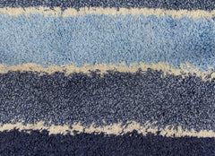 Close up of a high pile blue and white striped rug