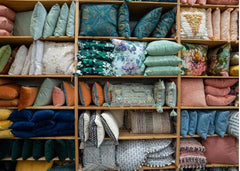 Shelves filled with all shapes and colors of throw pillows.