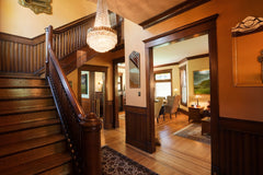 Looking into a historic home with wood molding, trim and stairs.