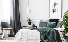 White bedroom, gray curtains, blue, gray and green accent pillows.