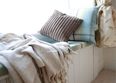 Window seat with pillows and blankets on top