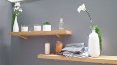 Gray wall, light wood shelves with white accents on the shelves.