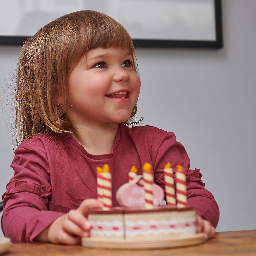 Child playing with pretend birthday cake