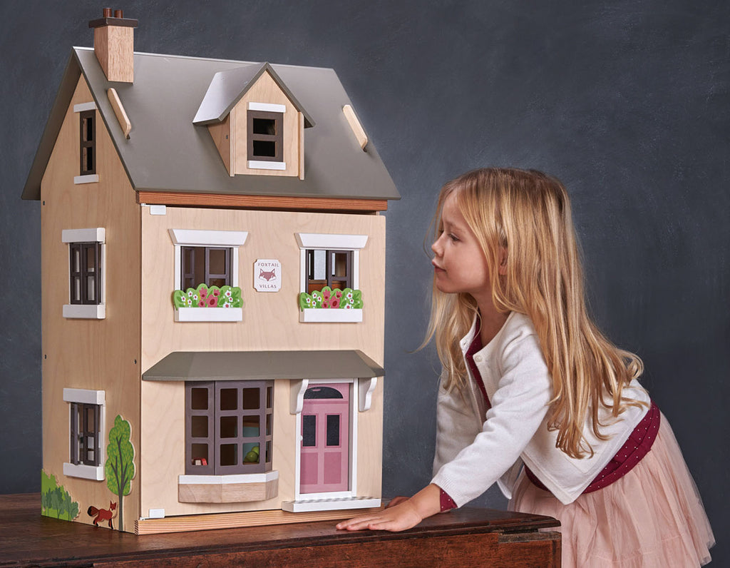 A girl looking through the window of a doll's house