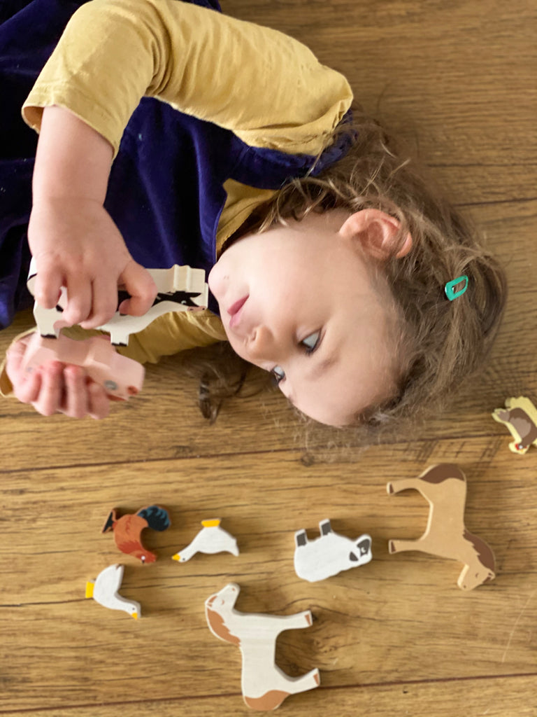 A child playing with wooden animals