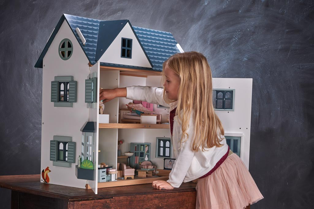 A girl playing at a doll's house
