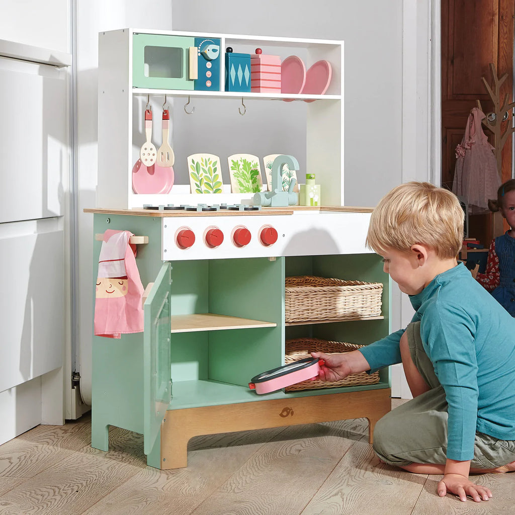 Boy playing at a toy kitchen