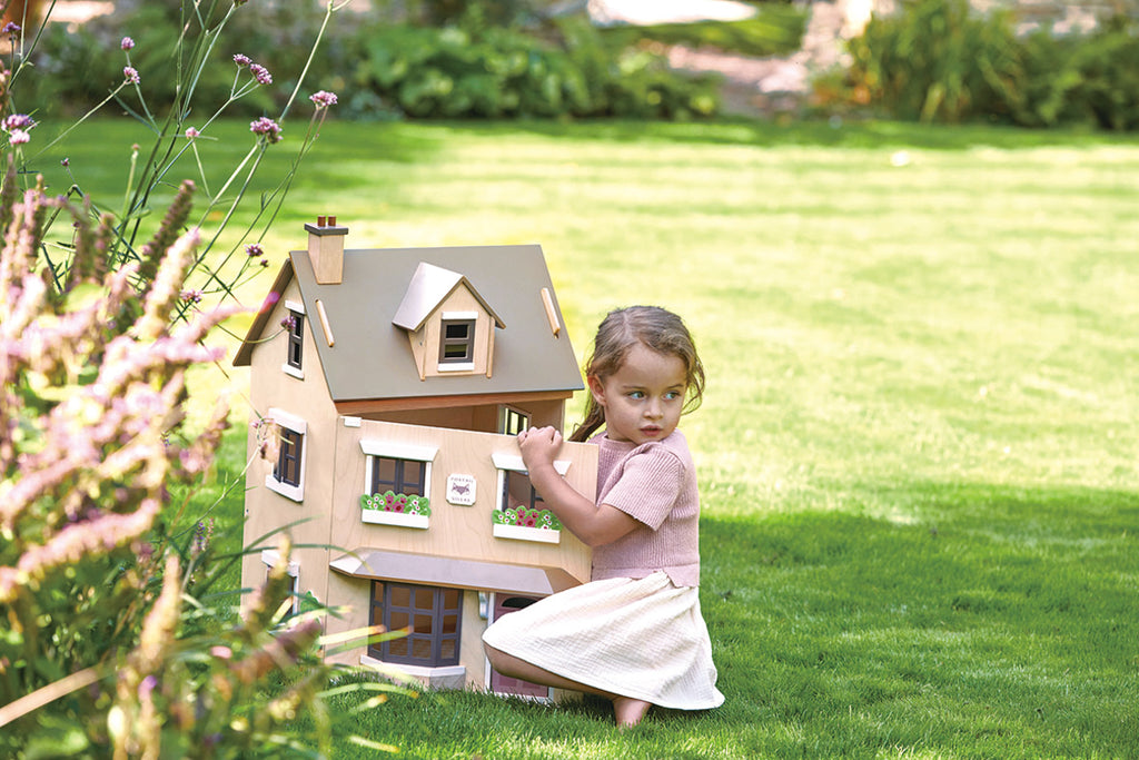 A girl at a doll's house in the garden