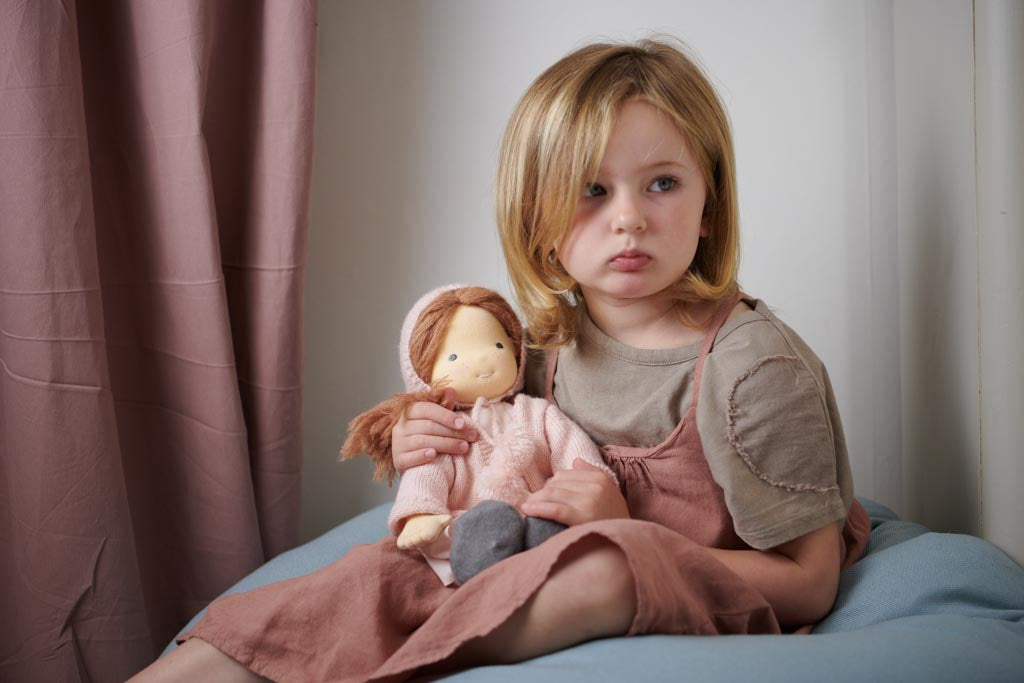 A girl holding a rag doll