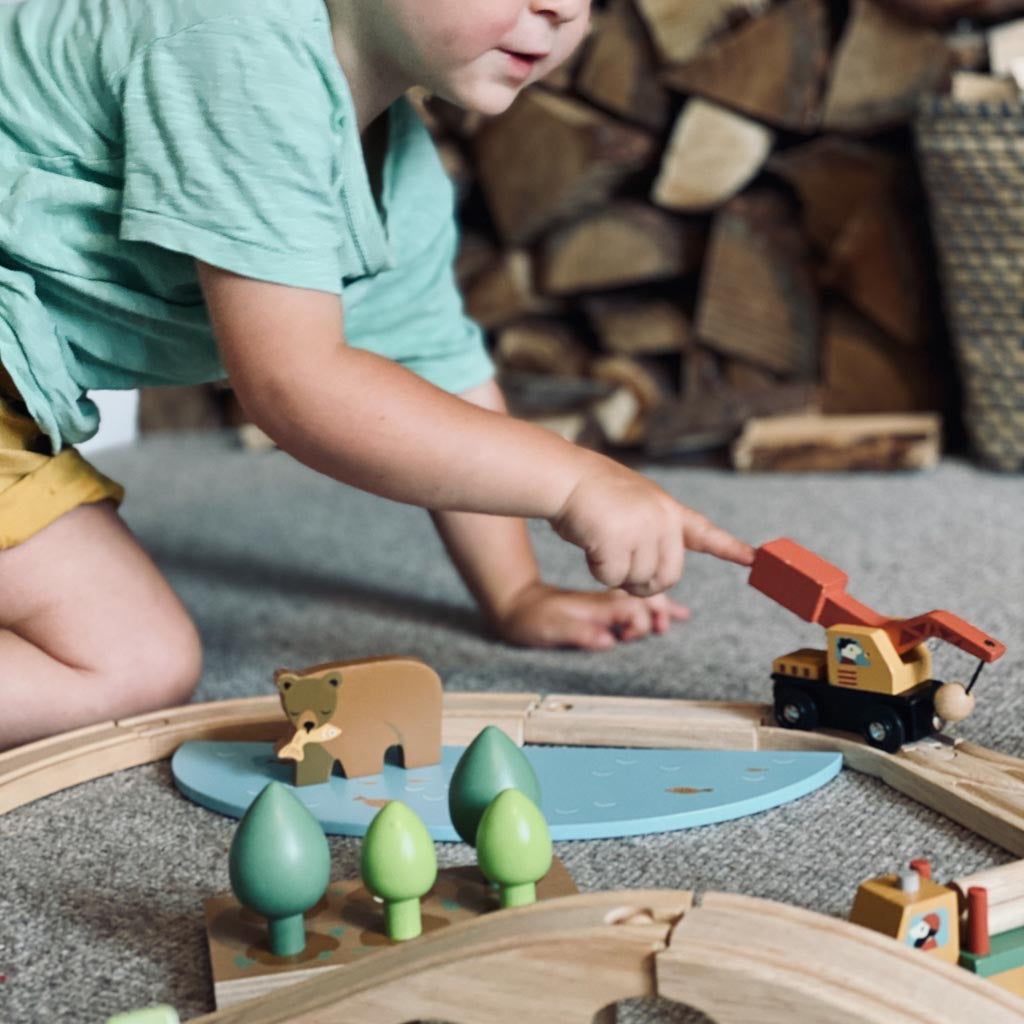 Boy playing with a wooden railway