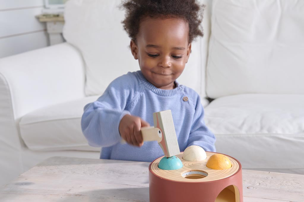 A toddler playing a hammering game