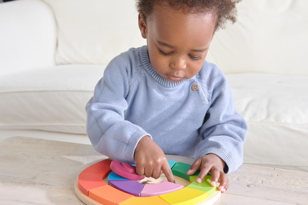 A toddler playing with a wooden puzzle