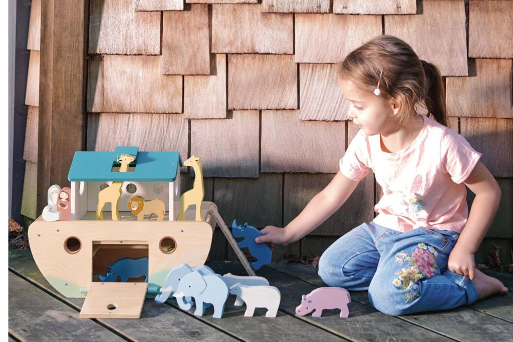 Girl playing with a wooden toy ark