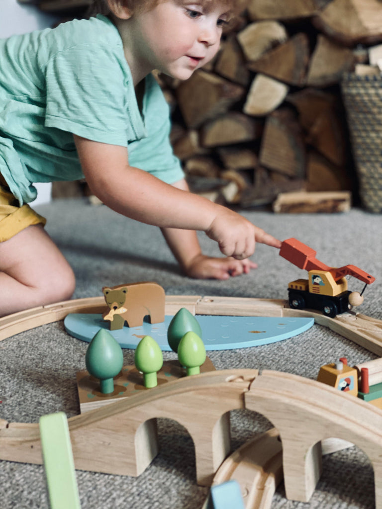 Child playing with a wooden train set