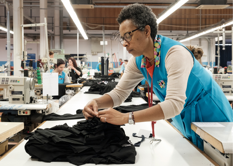 Women working over a sewing table in a factory in Portugal.