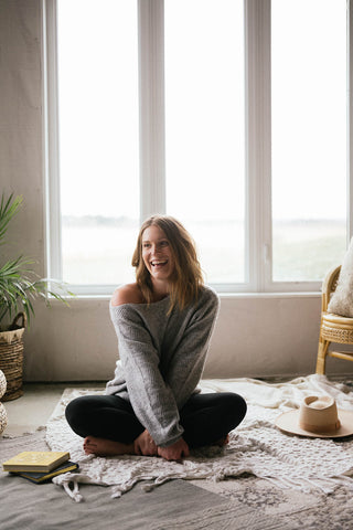 Women sitting on floor with legs crossed. 