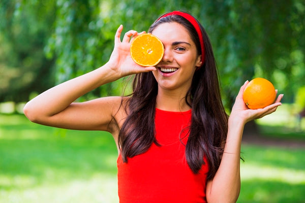 Woman with clear and radiant skin, holding oranges