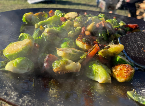 brussel sprouts being cooked on a skottle grill pan