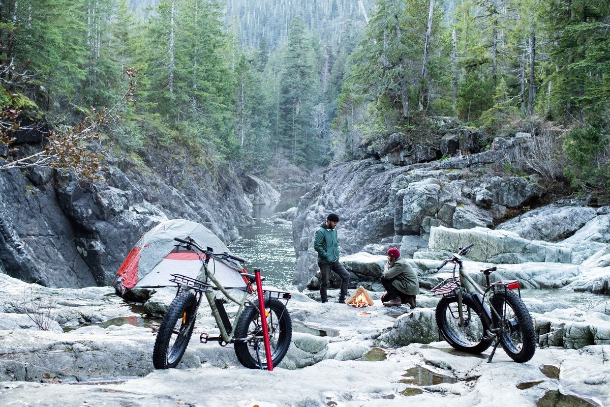 Two Surface 604 fat tire eBikes parked on rocky outcropping in the wilderness