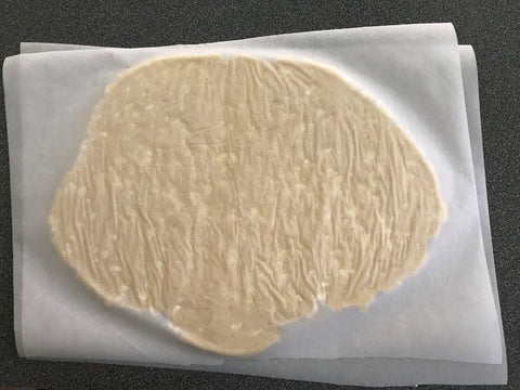Sugar cookie dough rolled out between parchment