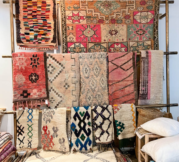 Several Moroccan rugs on a wall.