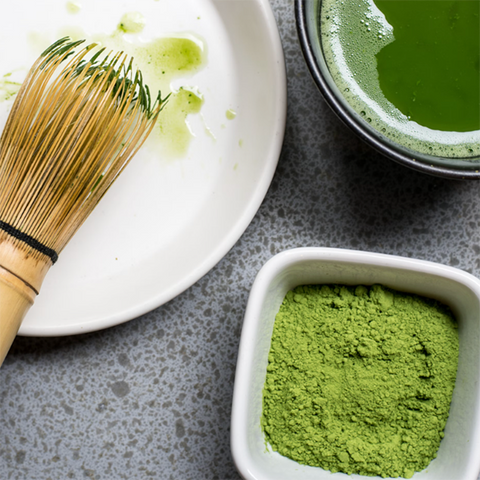 Green tea matcha powder, matcha whisk and matcha latte