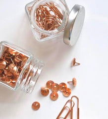 Bronze paperclips and drawing pins in jars