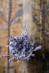 Lavender in a small jar on a wooden backdrop