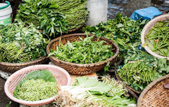 Herbs in baskets on floor of a stall