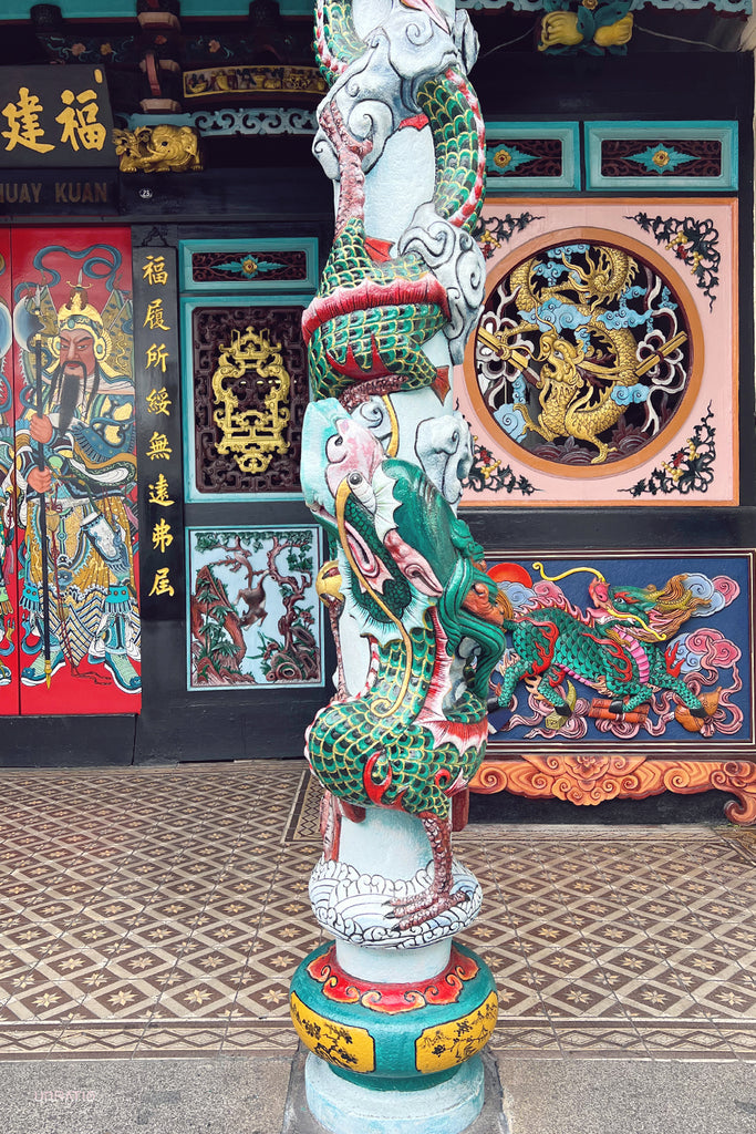Vibrant Peranakan shop front in Melaka with colorful murals, intricate carvings, and traditional Chinese motifs.