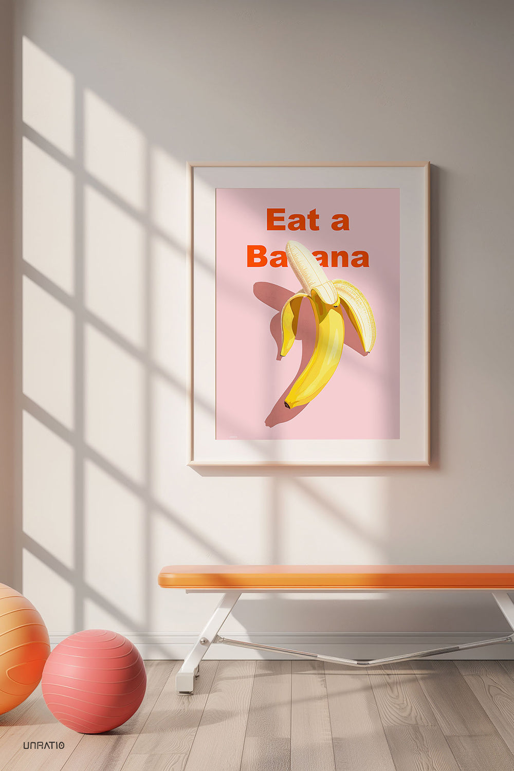 A modern home gym setting with a framed 'Eat a Banana' art print on the wall, flanked by exercise balls, promoting a healthy and stylish lifestyle.