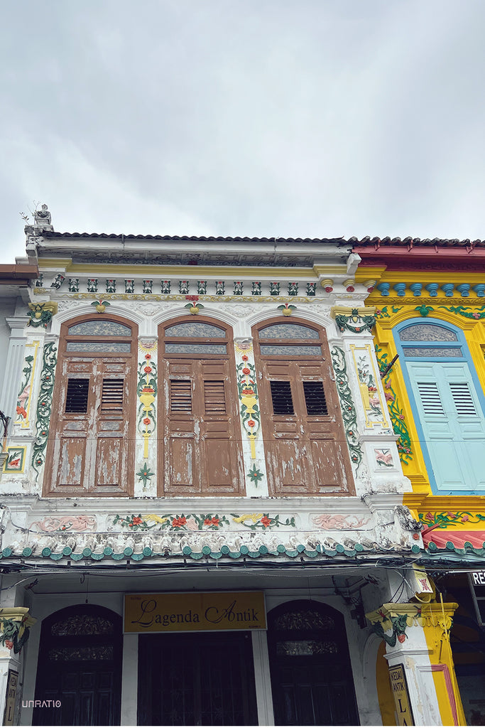Exquisite Peranakan architecture with decorative floral motifs and wooden shutters on a shop in Melaka.