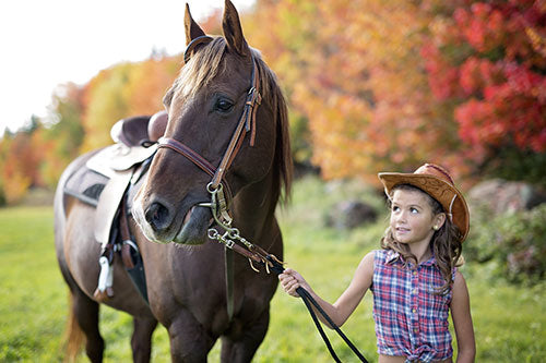 little girl leading a horse
